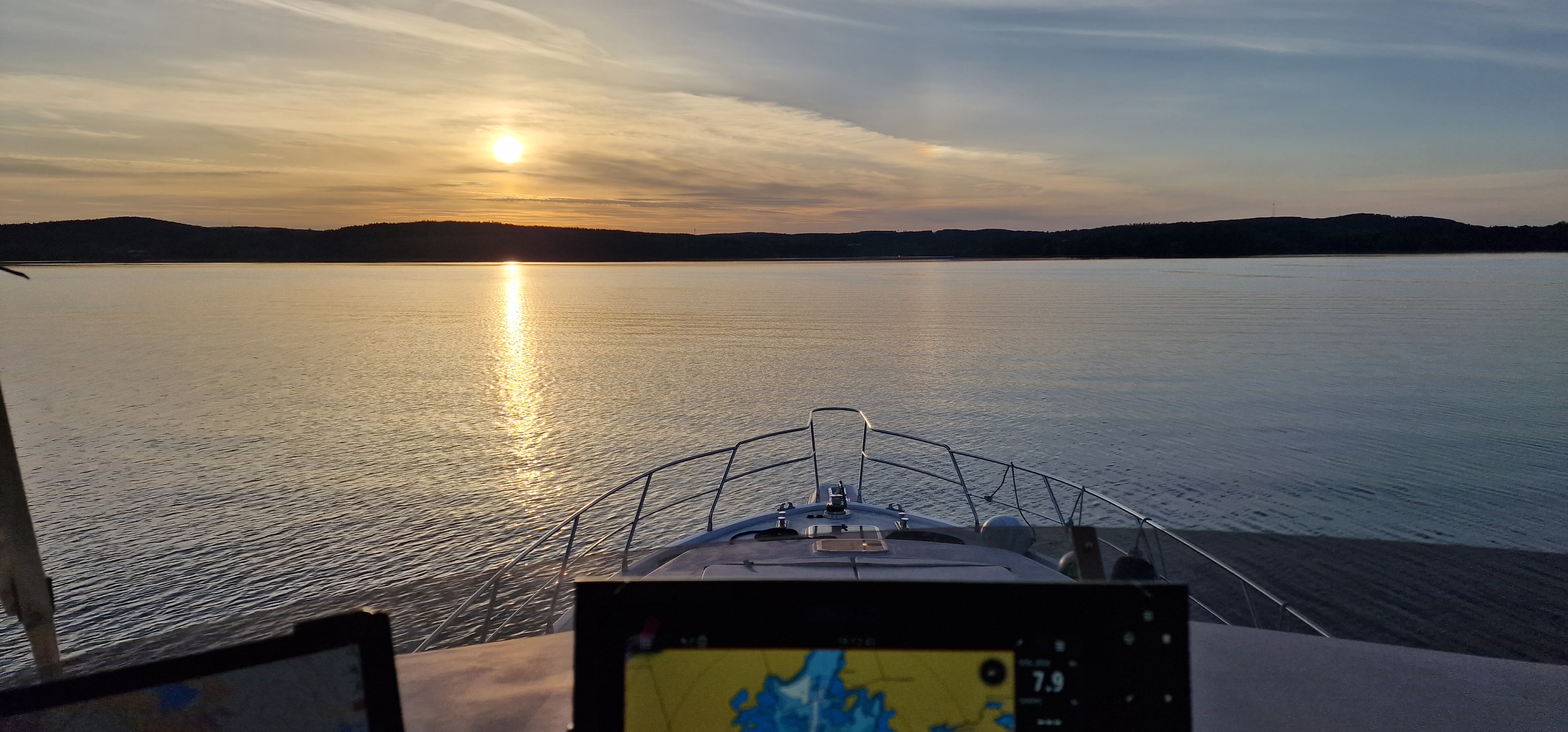 Auringonlasku järvellä jahdin keulasta nähtynä